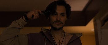 Movie still from “Destroyer” (2018), directed by Karyn Kusama – A man with long hair is getting his hair cut; Close Up shot, Low angle