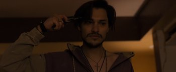 Movie still from “Destroyer” (2018), directed by Karyn Kusama – A man with long hair is getting his hair cut; Close Up shot, Low angle