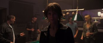 Movie still from “Destroyer” (2018), directed by Karyn Kusama – A woman in a leather jacket is looking at the camera; Medium shot, Over the shoulder angle