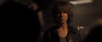 Movie still from “Destroyer” (2018), directed by Karyn Kusama – A woman in a leather jacket looking at the camera; Close Up shot, Over the shoulder angle