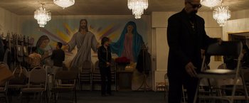 Movie still from “Destroyer” (2018), directed by Karyn Kusama – A woman standing in front of a painting of jesus and mary; Wide shot, Low angle