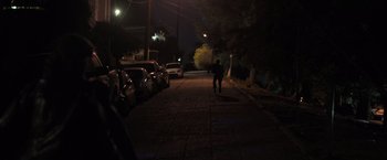 Movie still from “Destroyer” (2018), directed by Karyn Kusama – A person walking down a street at night; Extreme Wide shot, High angle
