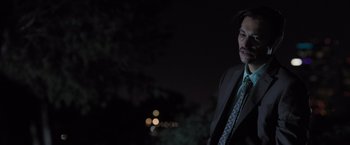 Movie still from “Destroyer” (2018), directed by Karyn Kusama – A man wearing a suit and tie standing in the dark; Close Up shot, Low angle