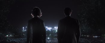 Movie still from “Destroyer” (2018), directed by Karyn Kusama – A man and a woman looking out over a city at night; Medium shot, Low angle