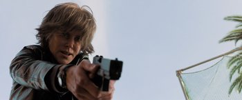 Movie still from “Destroyer” (2018), directed by Karyn Kusama – A young man holding a gun in his hands; Close Up shot, Low angle
