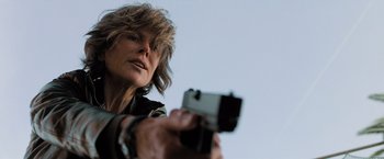 Movie still from “Destroyer” (2018), directed by Karyn Kusama – A woman is holding a gun in her hand; Close Up shot, Low angle