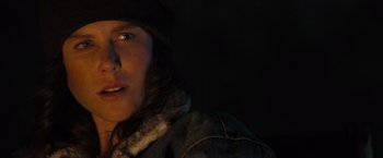 Movie still from “Destroyer” (2018), directed by Karyn Kusama – A person with a hat and a jacket on in the dark; Close Up shot, Low angle