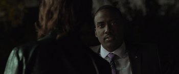 Movie still from “Destroyer” (2018), directed by Karyn Kusama – A man wearing a suit and tie in the dark; Close Up shot, Over the shoulder angle