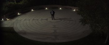 Movie still from “Destroyer” (2018), directed by Karyn Kusama – A man standing in the middle of a labyrinth at night; Extreme Wide shot, High angle