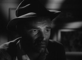 Movie still from “Detour” (1945), directed by Edgar G. Ulmer – A black and white photo of a man wearing a hat; Close Up shot, Low angle