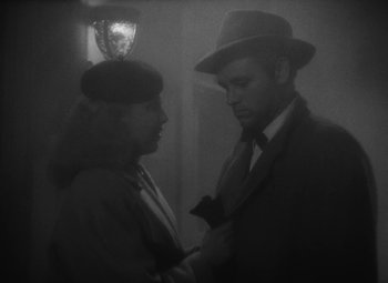 Movie still from “Detour” (1945), directed by Edgar G. Ulmer – A man and a woman standing next to each other; Close Up shot, High angle