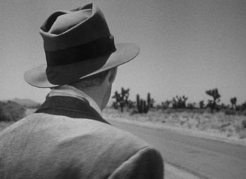 Movie still from “Detour” (1945), directed by Edgar G. Ulmer – A black and white photo of a man wearing a hat; Close Up shot, Over the shoulder angle