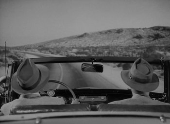 Movie still from “Detour” (1945), directed by Edgar G. Ulmer – A view from a car's windshield of a road; Close Up shot, Low angle