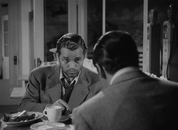 Movie still from “Detour” (1945), directed by Edgar G. Ulmer – Two men sitting at a table with a cup of coffee; Medium shot, Over the shoulder angle