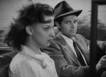 Movie still from “Detour” (1945), directed by Edgar G. Ulmer – A man and a woman are sitting next to each other; Close Up shot, Low angle