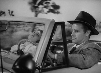 Movie still from “Detour” (1945), directed by Edgar G. Ulmer – A man and a woman in the back seat of a car; Medium shot, Low angle