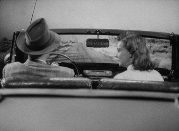Movie still from “Detour” (1945), directed by Edgar G. Ulmer – A man and a woman in the back seat of a car; Medium shot, High angle