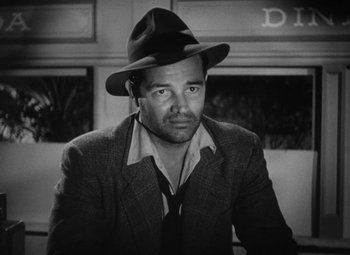 Movie still from “Detour” (1945), directed by Edgar G. Ulmer – A black and white photo of a man wearing a hat; Close Up shot, Low angle