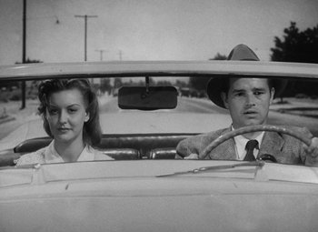 Movie still from “Detour” (1945), directed by Edgar G. Ulmer – A man and a woman sitting in the back seat of a car; Medium shot, Low angle