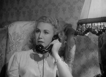 Movie still from “Detour” (1945), directed by Edgar G. Ulmer – A black and white photo of a woman talking on a phone; Close Up shot, High angle