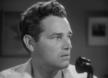 Movie still from “Detour” (1945), directed by Edgar G. Ulmer – Black and white photograph of a man on a telephone; Close Up shot, Low angle