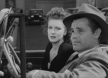 Movie still from “Detour” (1945), directed by Edgar G. Ulmer – A man and a woman sitting in the back of a car; Close Up shot, Over the shoulder angle