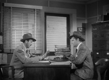 Movie still from “Detour” (1945), directed by Edgar G. Ulmer – A couple of men sitting at a table in a room; Wide shot, High angle