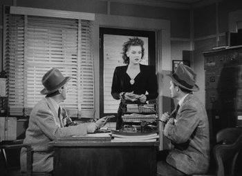 Movie still from “Detour” (1945), directed by Edgar G. Ulmer – Two men sitting at a table in front of a woman; Medium shot, Over the shoulder angle
