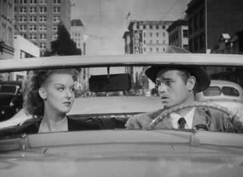 Movie still from “Detour” (1945), directed by Edgar G. Ulmer – A man and a woman sitting in the back of a car; Medium shot, High angle