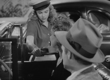 Movie still from “Detour” (1945), directed by Edgar G. Ulmer – A woman in a hat is holding a cell phone in her hand; Medium shot, Over the shoulder angle