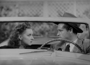 Movie still from “Detour” (1945), directed by Edgar G. Ulmer – A man and a woman sitting in the back seat of a car; Medium shot, High angle