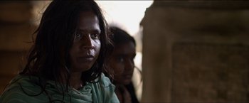 Movie still from “Dheepan” (2015), directed by Jacques Audiard – A woman standing next to a man in front of a wall; Close Up shot, Over the shoulder angle