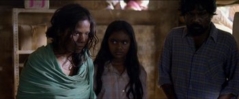 Movie still from “Dheepan” (2015), directed by Jacques Audiard – Two women and a man standing next to each other in a room; Close Up shot, High angle