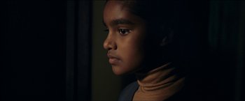 Movie still from “Dheepan” (2015), directed by Jacques Audiard – A person's face in a dark room; Close Up shot, Over the shoulder angle
