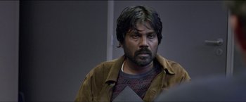 Movie still from “Dheepan” (2015), directed by Jacques Audiard – A person wearing a jacket; Close Up shot, Over the shoulder angle