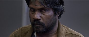 Movie still from “Dheepan” (2015), directed by Jacques Audiard – A person with a beard; Close Up shot, Over the shoulder angle