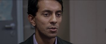 Movie still from “Dheepan” (2015), directed by Jacques Audiard – A person wearing a suit and tie; Close Up shot, Over the shoulder angle