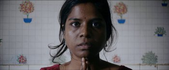 Movie still from “Dheepan” (2015), directed by Jacques Audiard – A person with her hands clasped together; Close Up shot, Low angle
