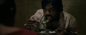 Movie still from “Dheepan” (2015), directed by Jacques Audiard – A man eating rice with chopsticks in a bowl; Close Up shot, High angle