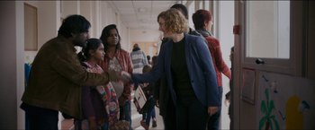 Movie still from “Dheepan” (2015), directed by Jacques Audiard – A group of people in a hallway shaking hands with each other; Medium shot, Over the shoulder angle