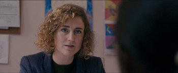 Movie still from “Dheepan” (2015), directed by Jacques Audiard – A person sitting in a room; Close Up shot, Over the shoulder angle