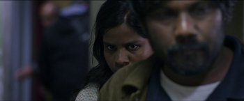 Movie still from “Dheepan” (2015), directed by Jacques Audiard – A person with a jacket over their face; Close Up shot, Over the shoulder angle