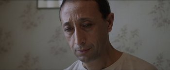 Movie still from “Dheepan” (2015), directed by Jacques Audiard – A person with a sad look on his face; Close Up shot, Low angle