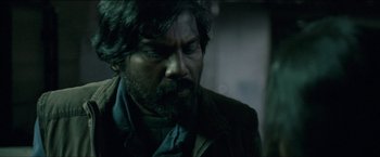 Movie still from “Dheepan” (2015), directed by Jacques Audiard – A person with a beard; Close Up shot, Over the shoulder angle