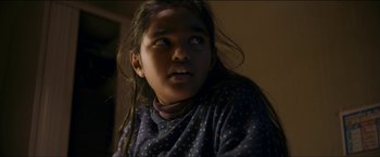 Movie still from “Dheepan” (2015), directed by Jacques Audiard – A young girl with long black hair looking up at the ceiling; Close Up shot, Low angle