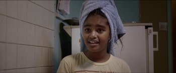 Movie still from “Dheepan” (2015), directed by Jacques Audiard – A young girl with a towel on her head; Close Up shot, Over the shoulder angle
