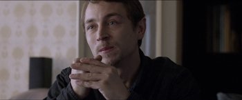 Movie still from “Dheepan” (2015), directed by Jacques Audiard – A person with his hands clasped together; Close Up shot, Over the shoulder angle