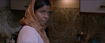 Movie still from “Dheepan” (2015), directed by Jacques Audiard – A woman with a head scarf is looking at the camera; Close Up shot, Over the shoulder angle