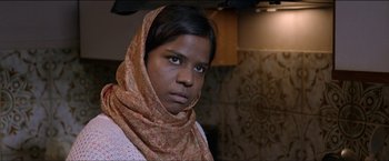 Movie still from “Dheepan” (2015), directed by Jacques Audiard – A woman wearing a head scarf in a kitchen; Close Up shot, Low angle