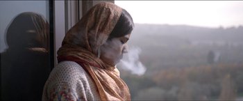 Movie still from “Dheepan” (2015), directed by Jacques Audiard – A woman in a scarf looking out of a window; Close Up shot, Low angle